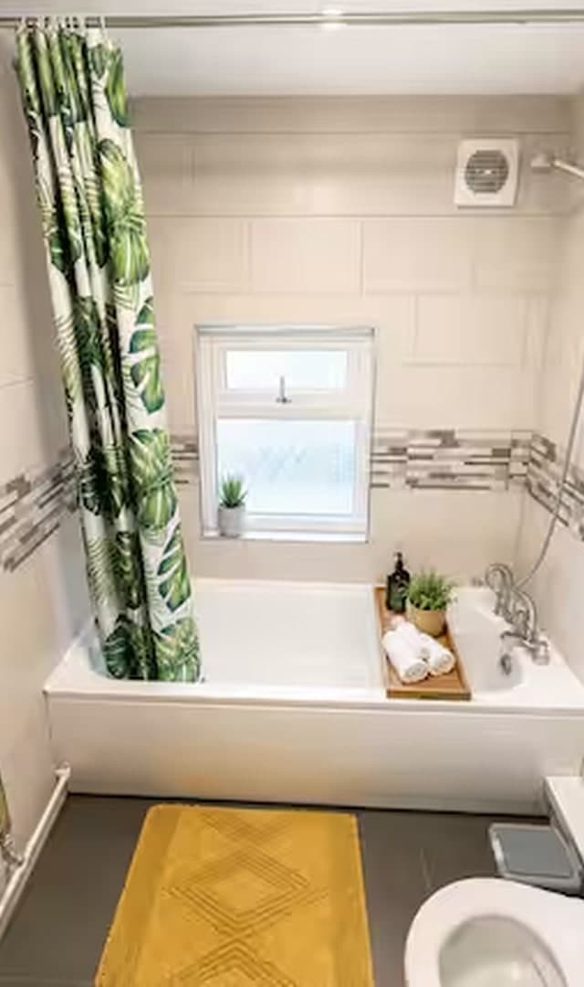 Private bathroom with bathtub and overhead shower