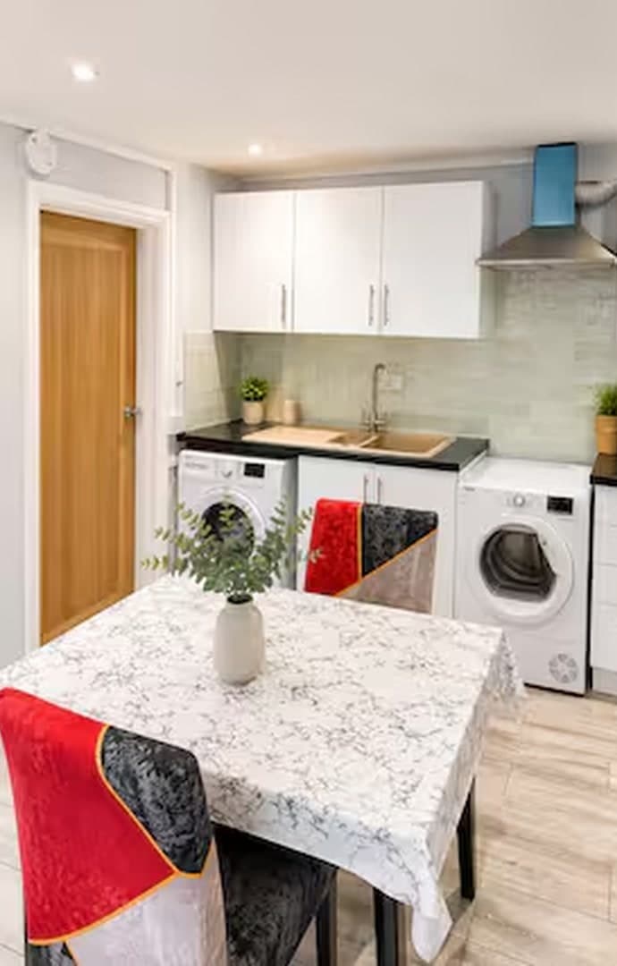 Kitchen area with washing machine and dining table